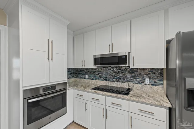 a kitchen with stainless steel appliances granite countertop a stove a sink and a refrigerator