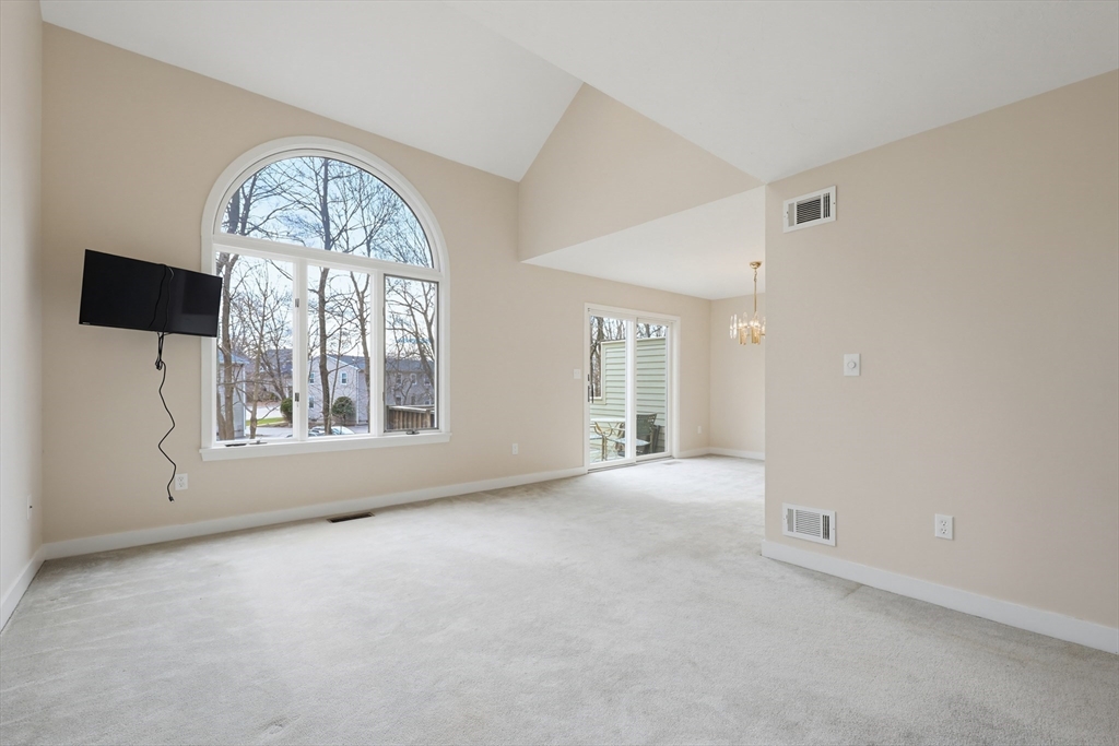 38 Poppasquash Road, Unit 38 North Attleboro, MA 02760 - Photo 12 of 36 an empty room with chandelier fan and windows