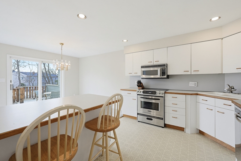 38 Poppasquash Road, Unit 38 North Attleboro, MA 02760 - Photo 7 of 36 a kitchen with stainless steel appliances granite countertop a stove a sink dishwasher a microwave oven with a dining table and chairs