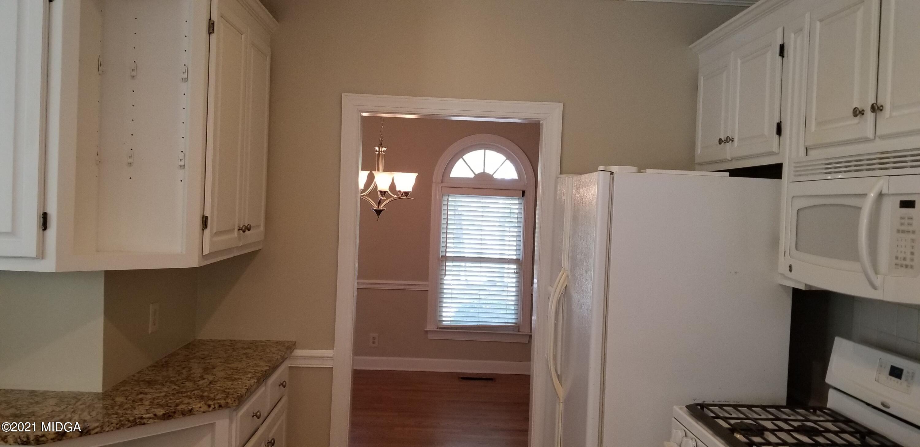 208 Gates Road Lizella, GA 31052 - Photo 8 of 55 a kitchen with granite countertop white cabinets and white appliances