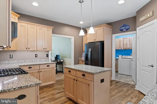 a kitchen with granite countertop a sink stainless steel appliances and cabinets
