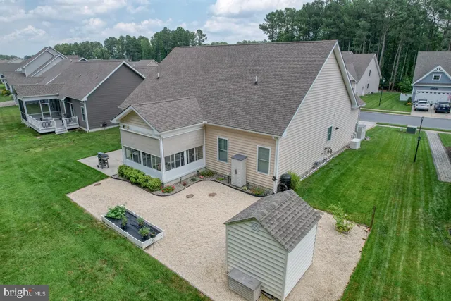 an aerial view of a house with a garden and lake view