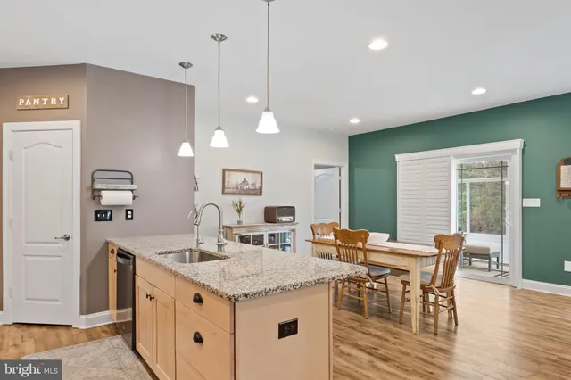 a kitchen with a dining table chairs wooden floor and appliances