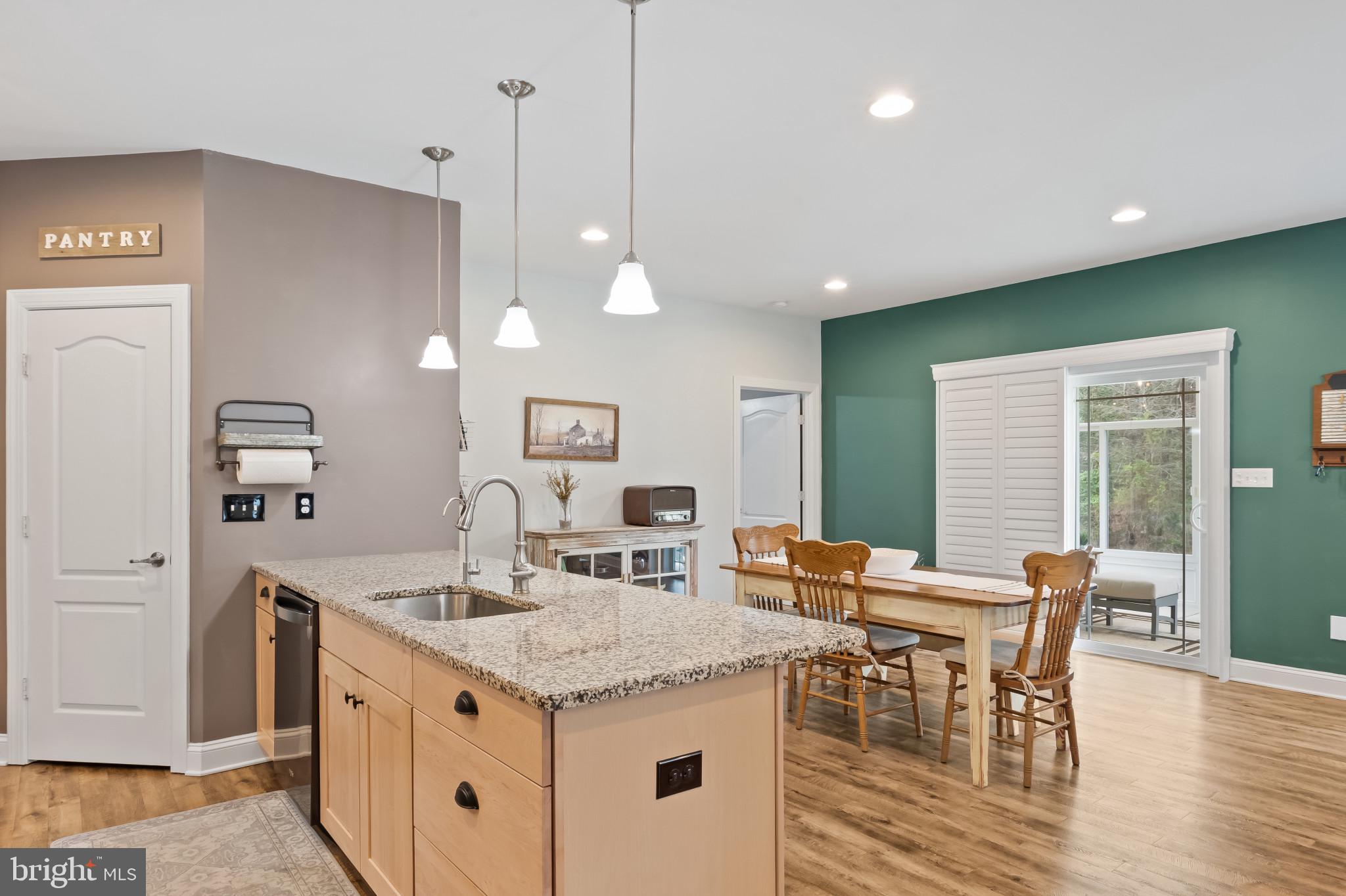 18067 Emerson Way Georgetown, DE 19947 - Photo 3 of 37 a kitchen with a dining table chairs wooden floor and appliances