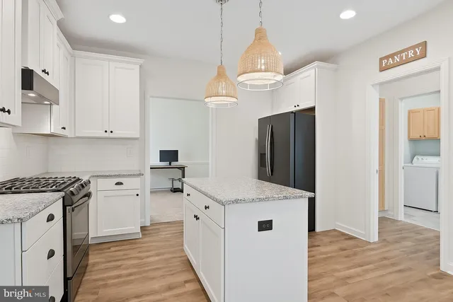 a kitchen with granite countertop a sink stove and refrigerator