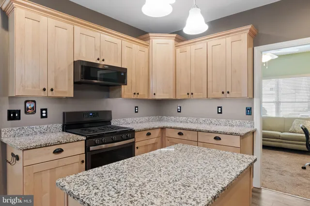 a kitchen with stainless steel appliances granite countertop a stove sink and cabinets