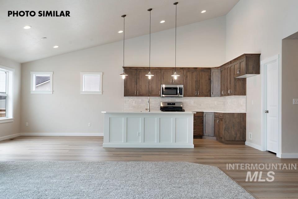 1645 Haystack Emmett, ID 83617 - Photo 8 of 33 Open-concept kitchen featuring dark wood-finish cabinetry, stainless steel appliances, and a white subway tile backsplash
