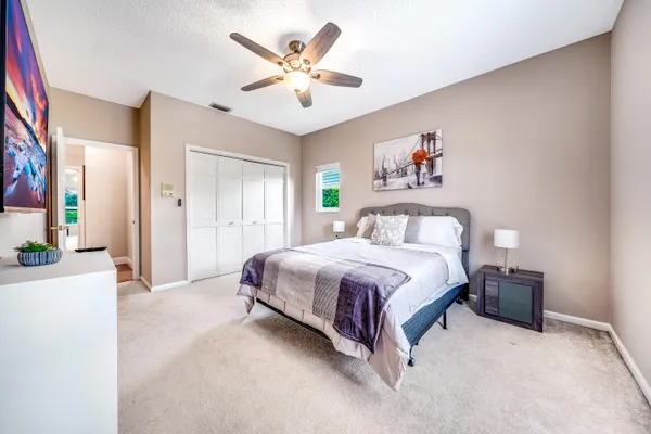 a spacious bedroom with a bed and a chandelier
