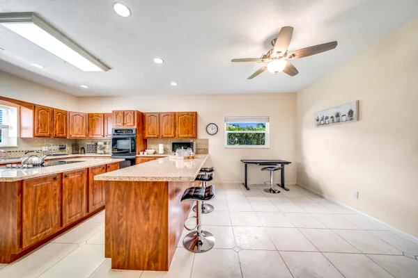 a living room with stainless steel appliances kitchen island granite countertop furniture and a view of kitchen