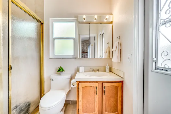a bathroom with a granite countertop sink toilet and large mirror