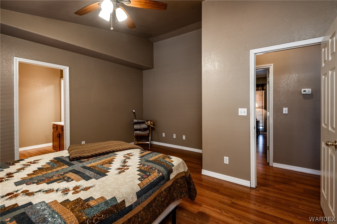 10363 East Blake Ranch Road Kingman, AZ 86401 - Photo 20 of 79 a bedroom with a bed and a chandelier