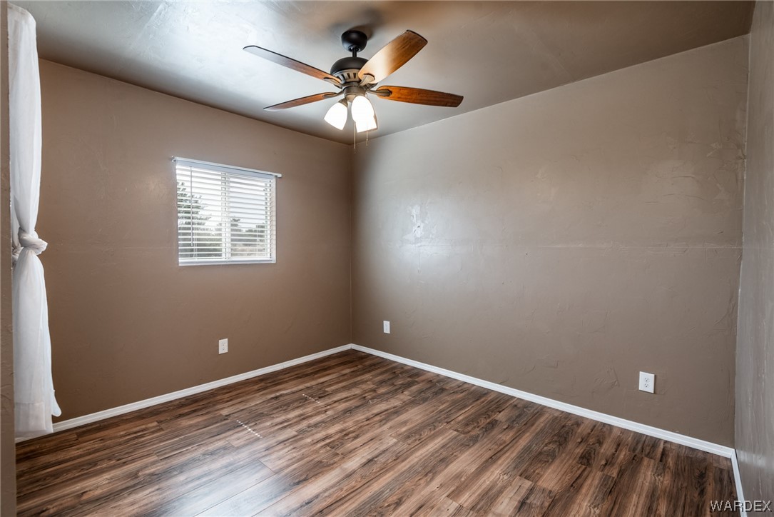 10363 East Blake Ranch Road Kingman, AZ 86401 - Photo 75 of 79 an empty room with wooden floor fan and windows