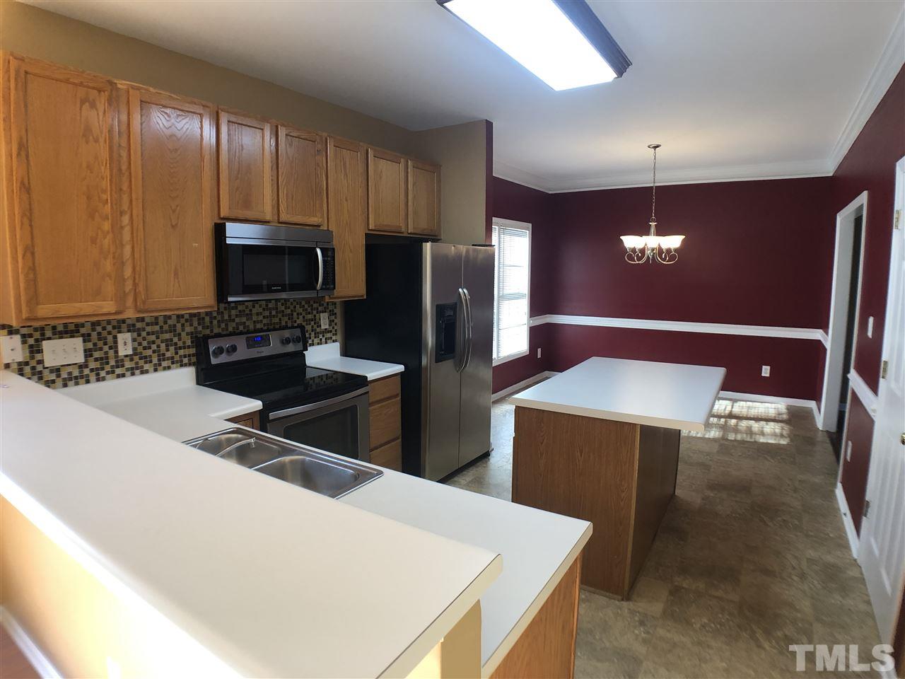 2400 Clerestory Place Raleigh, NC 27615 - Photo 14 of 30 a kitchen with stainless steel appliances a refrigerator a stove a microwave and island