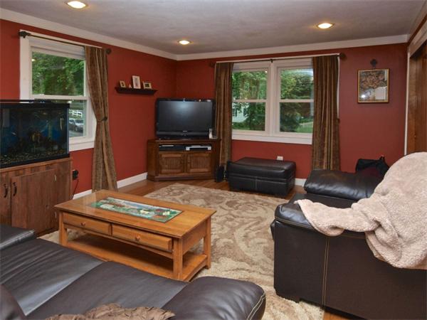 42 Felch Road Natick, MA 01760 - Photo 2 of 21 a living room with furniture a flat screen tv and a floor to ceiling window