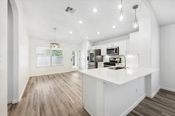 a kitchen with stainless steel appliances granite countertop a sink stove and refrigerator