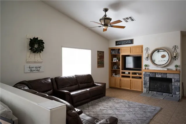 a living room with furniture a clock and a flat screen tv