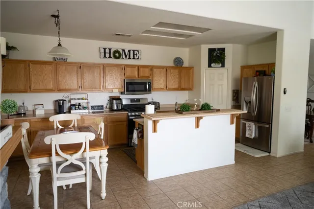 a kitchen with kitchen island a counter top space appliances and cabinets