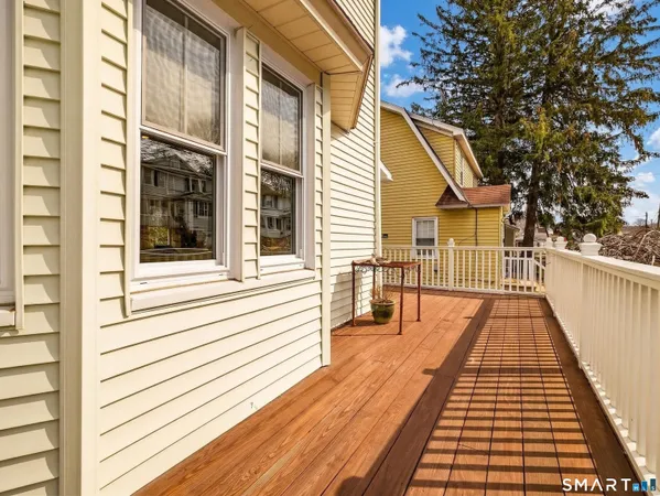 a view of a balcony with wooden floor and fence
