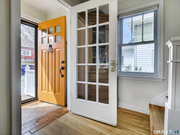 a view of a hallway with wooden floor and staircase