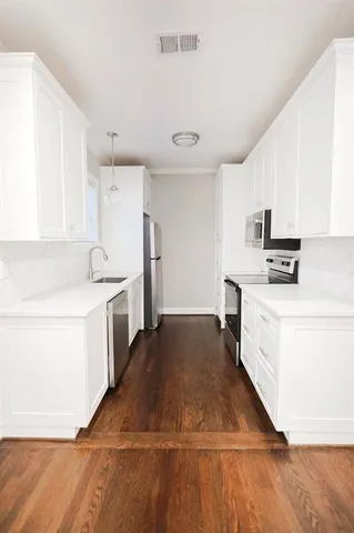 a kitchen with granite countertop white cabinets and white appliances