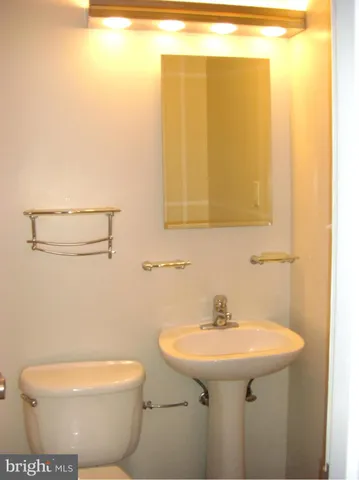 a bathroom with a sink a toilet and mirror