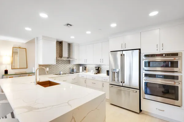 a kitchen with refrigerator and white cabinets