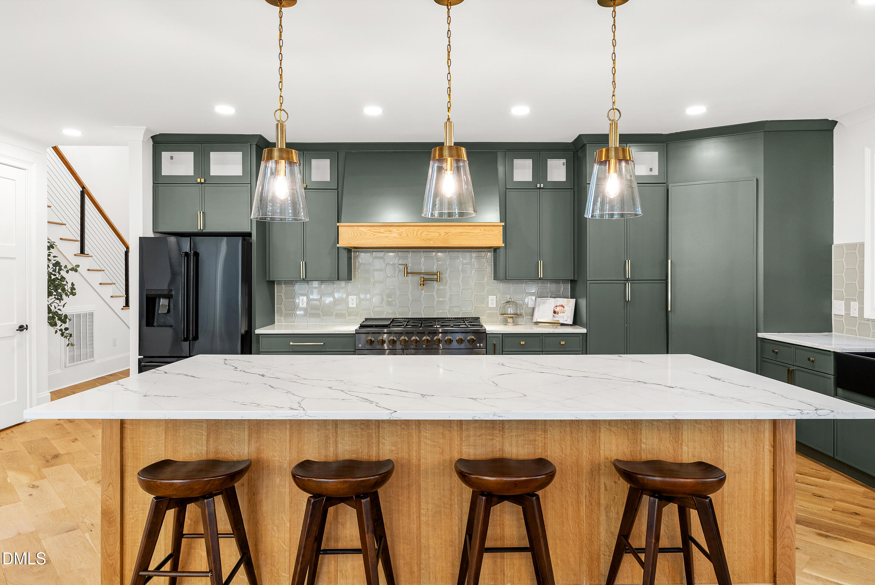 a kitchen with stainless steel appliances granite countertop a kitchen island and chairs in it