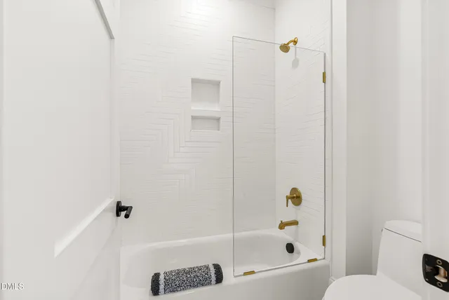 a bathroom with a toilet a sink a tub and mirror