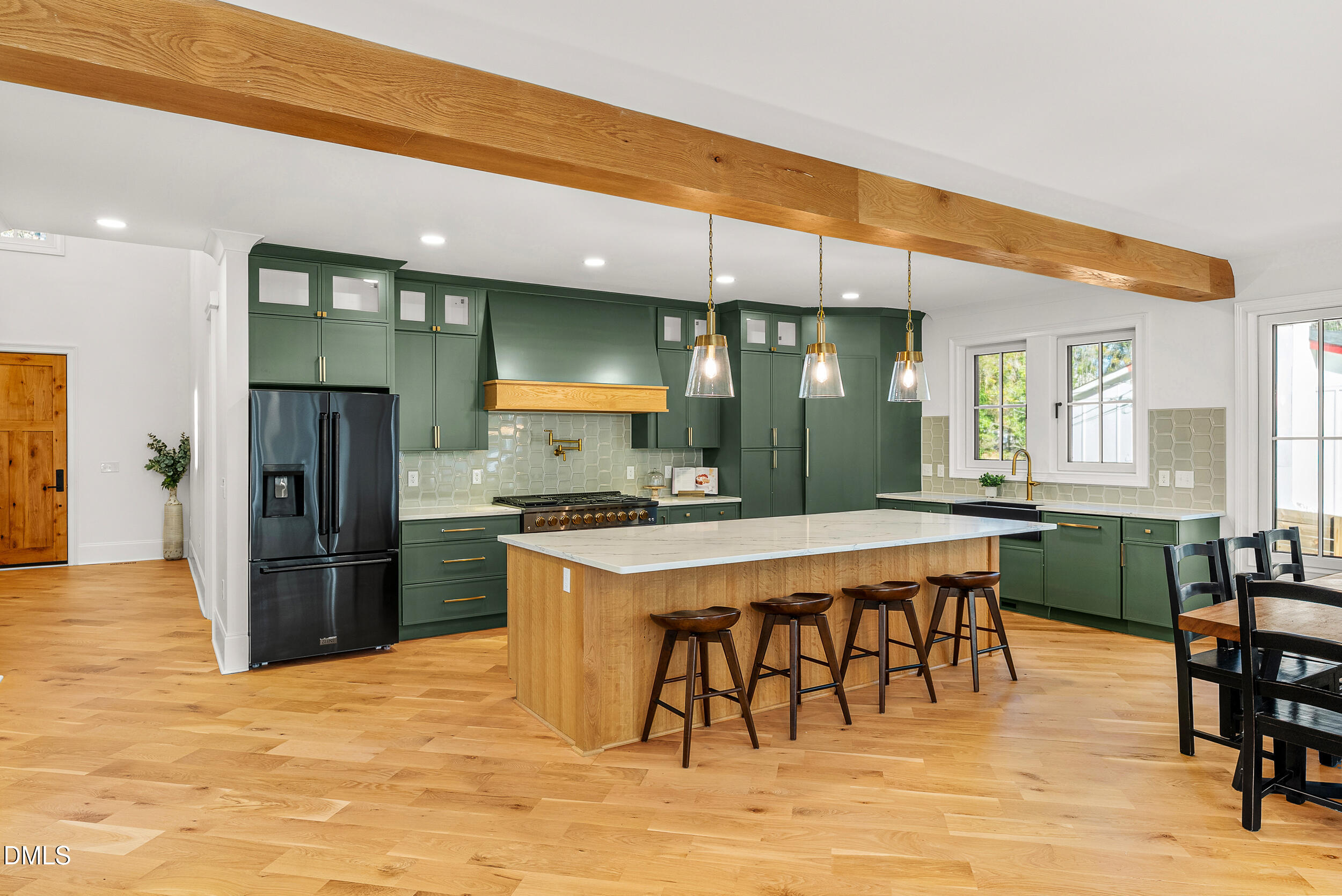 1232 Somerset Road Raleigh, NC 27610 - Photo 5 of 57 a kitchen with stainless steel appliances kitchen island granite countertop a refrigerator a stove a sink a dining table and chairs with wooden floor