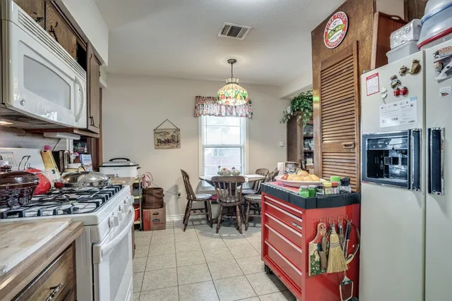 a kitchen with stainless steel appliances granite countertop a stove and a dining table