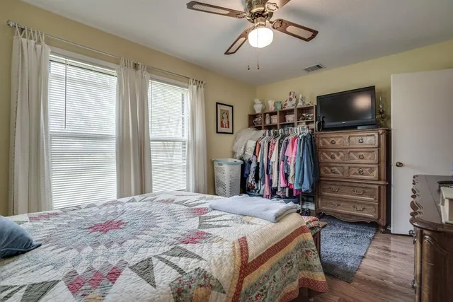 a bedroom with a bed and dresser with mirror