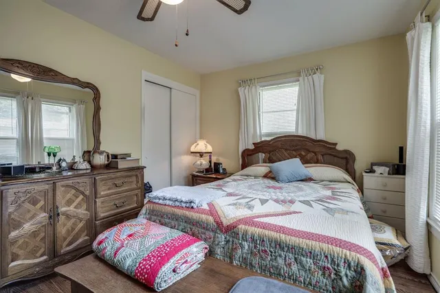 a bed room with a bed television and a large window