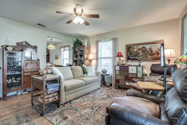 a living room with furniture a chandelier and a bookshelf
