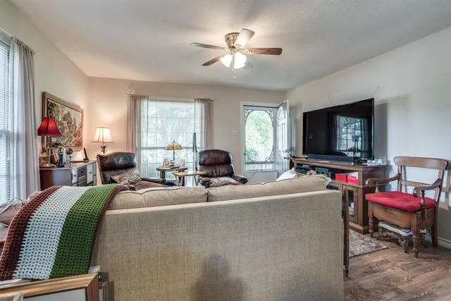 a living room with furniture a flat screen tv and a window