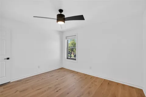 a view of a room with wooden floor and window