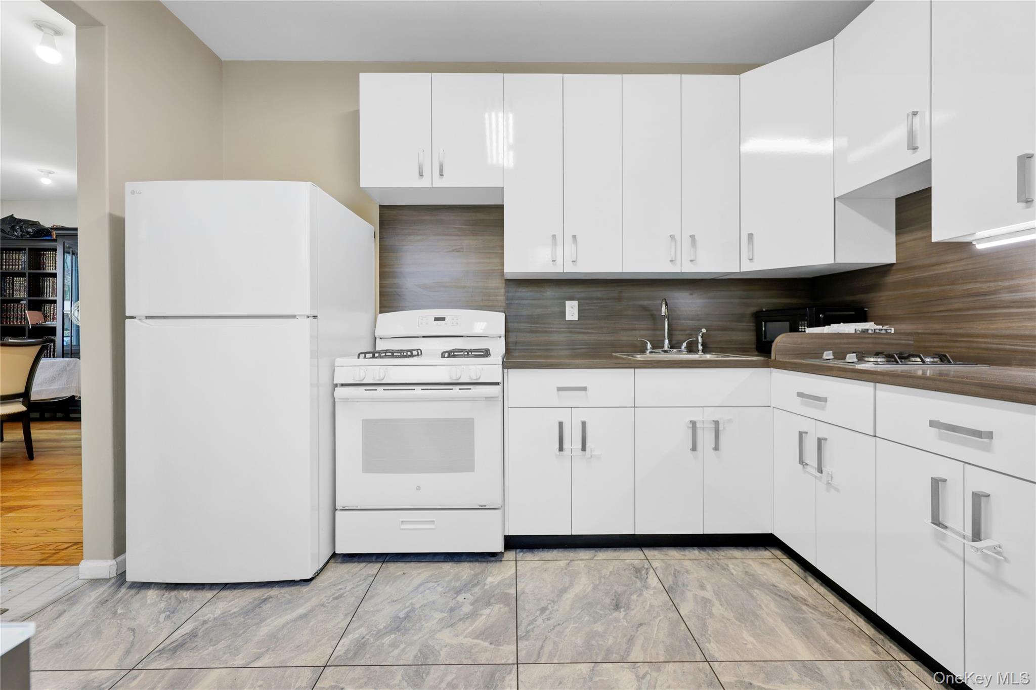 462 West Central Avenue, Unit 120 Spring Valley, NY 10977 - Photo 4 of 21 a kitchen with white cabinets a sink and white appliances