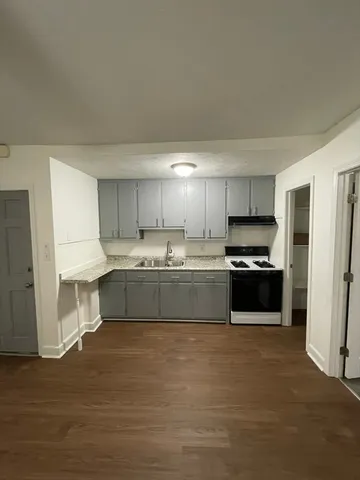 a large kitchen with cabinets a sink and a stove