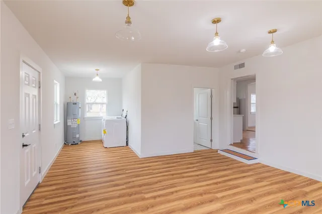 a view of a room with wooden floor and white walls