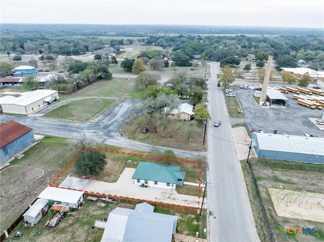 an aerial view of residential houses with outdoor space and parking