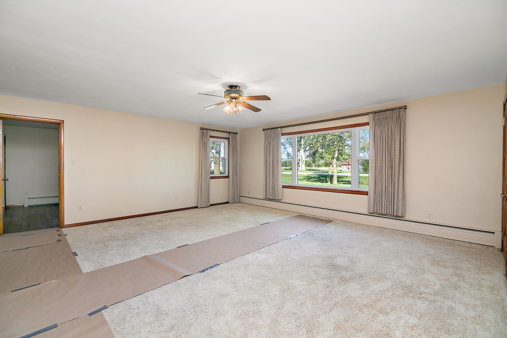 76 South 7000W Road Kankakee, IL 60901 - Photo 7 of 18 an empty room with windows and chandelier fan
