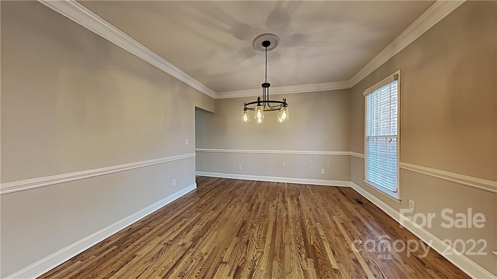 6415 Riverside Oaks Drive Huntersville, NC 28078 - Photo 2 of 22 a view of a room with wooden floor a ceiling fan and windows