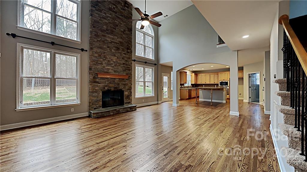 6415 Riverside Oaks Drive Huntersville, NC 28078 - Photo 3 of 22 an empty room with wooden floor fireplace and windows