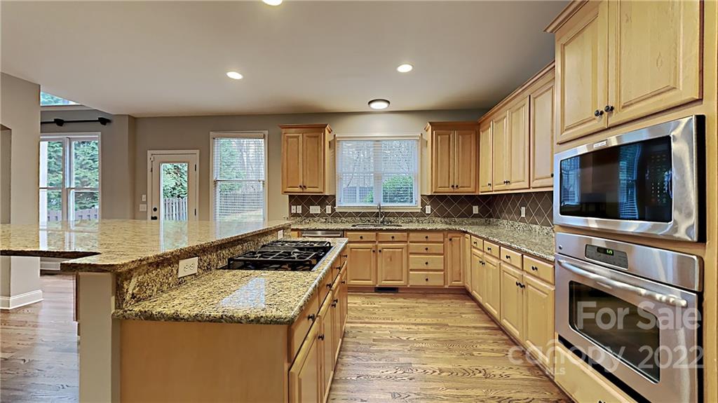 6415 Riverside Oaks Drive Huntersville, NC 28078 - Photo 4 of 22 a kitchen with granite countertop stainless steel appliances a stove sink and microwave