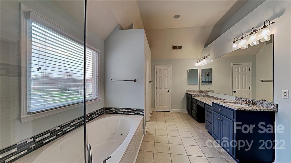 6415 Riverside Oaks Drive Huntersville, NC 28078 - Photo 8 of 22 a view of a bathroom with a double vanity sink a mirror and a bathtub