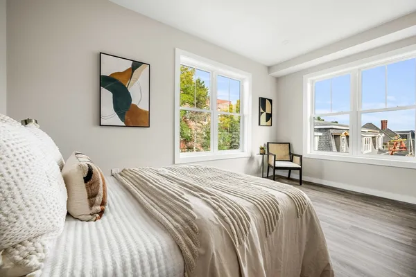a bedroom with a bed and a large window with outer view