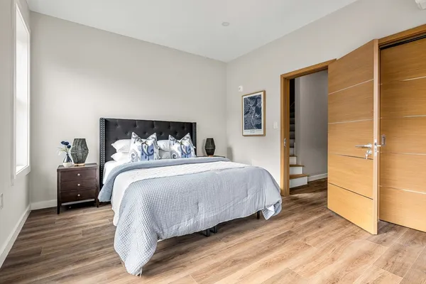 a bedroom with a bed and wooden floor