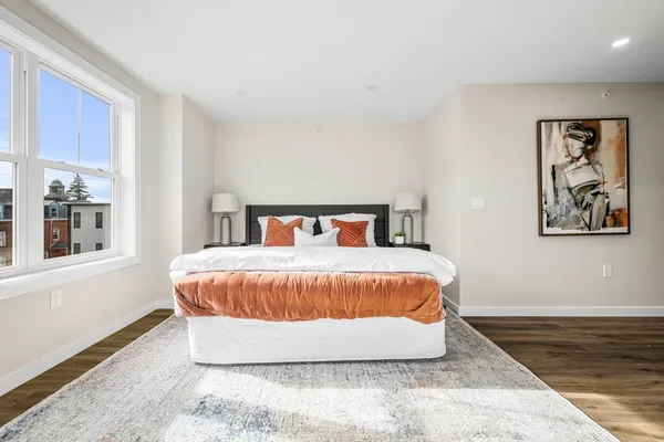 a bedroom with a bed and wooden floor