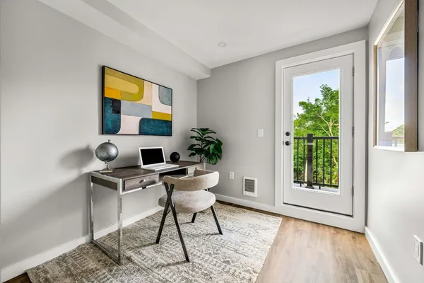 a view of a workspace with furniture and a window