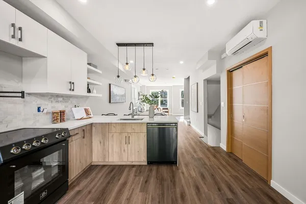 a kitchen with stainless steel appliances a white cabinets and wooden floor