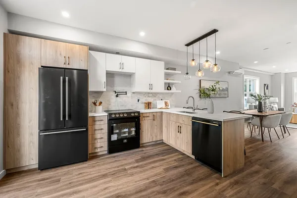 a kitchen with granite countertop a refrigerator stove and wooden floor